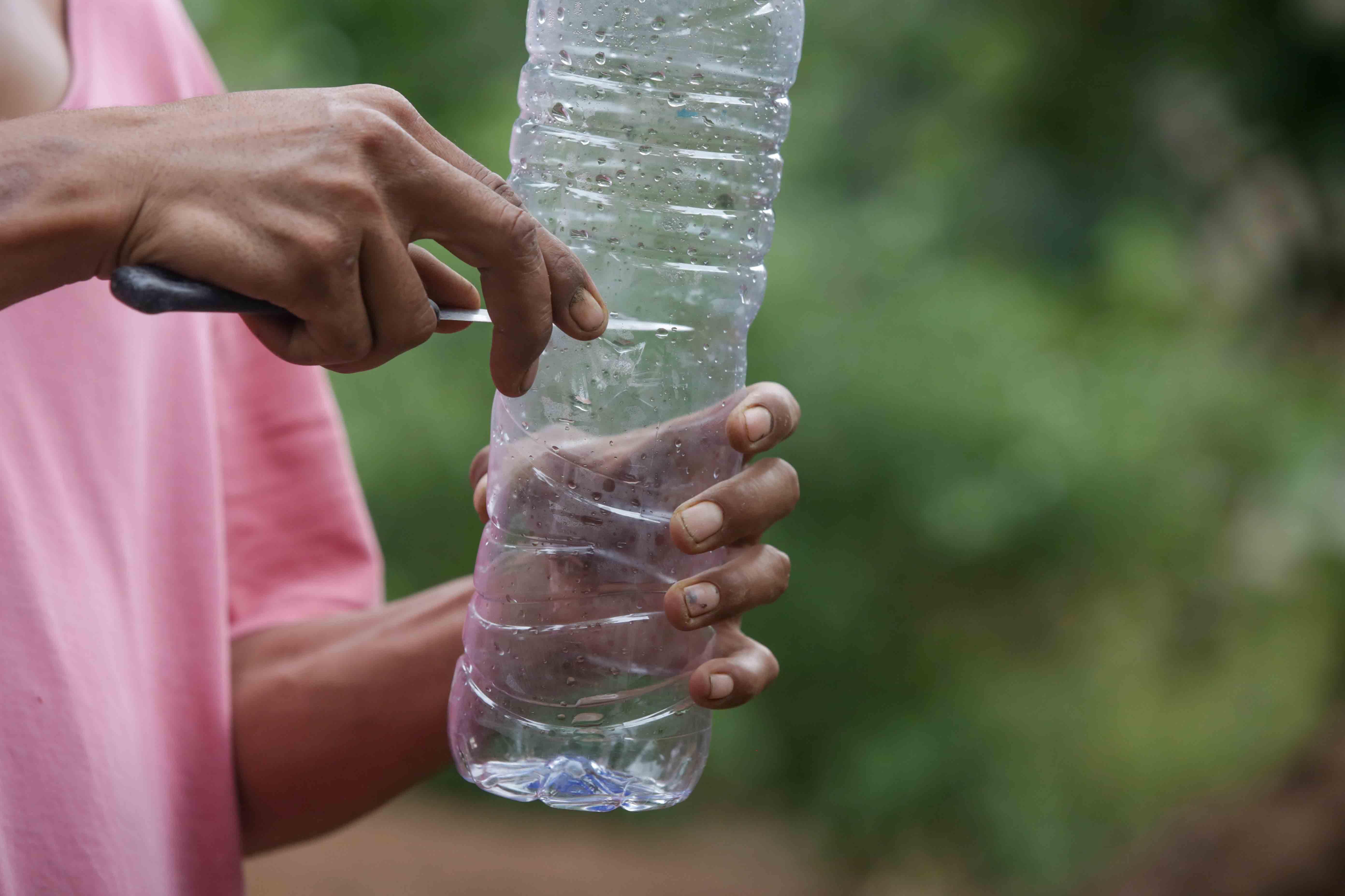 InnocentDrinks, person cutting a plastic bottle